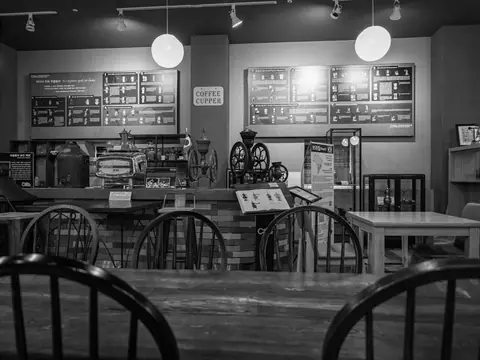 Café seating area with wooden chairs and a menu board