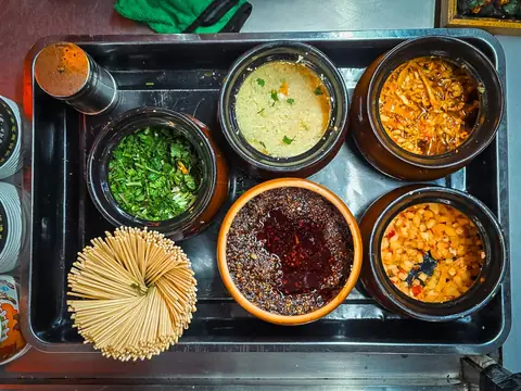 Small jars of colorful sauces and condiments on a tray