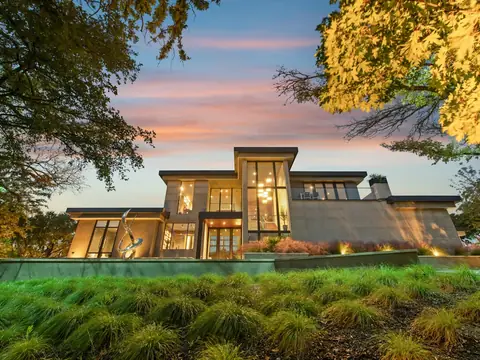 Modern house with large lit windows at dusk